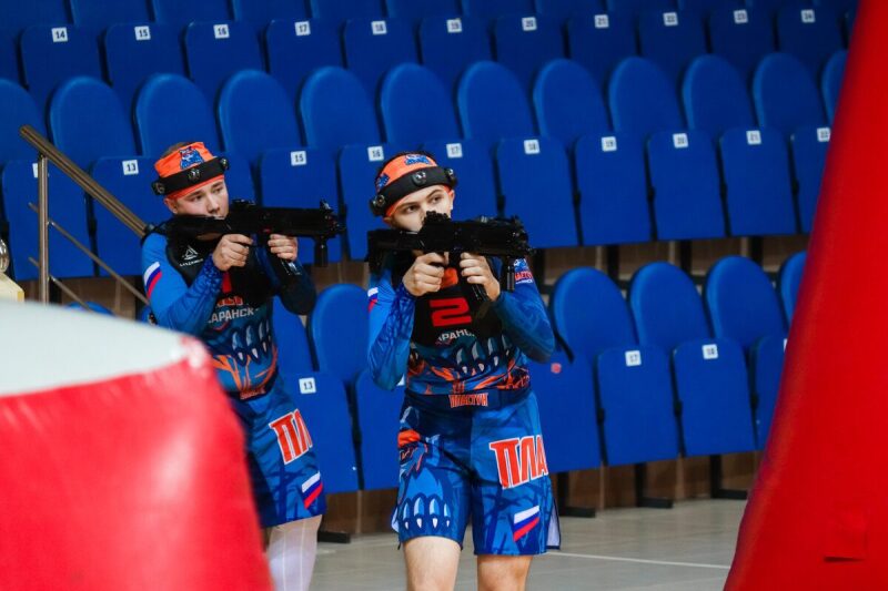 Два бойца LASERWAR прицеливаются из-за надувных укрытий.